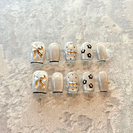 Noir Bow – Grey Sheer Luxury Press-On Nails with 3D Gold Ribbon & Floral Accents – Short Squoval Shape